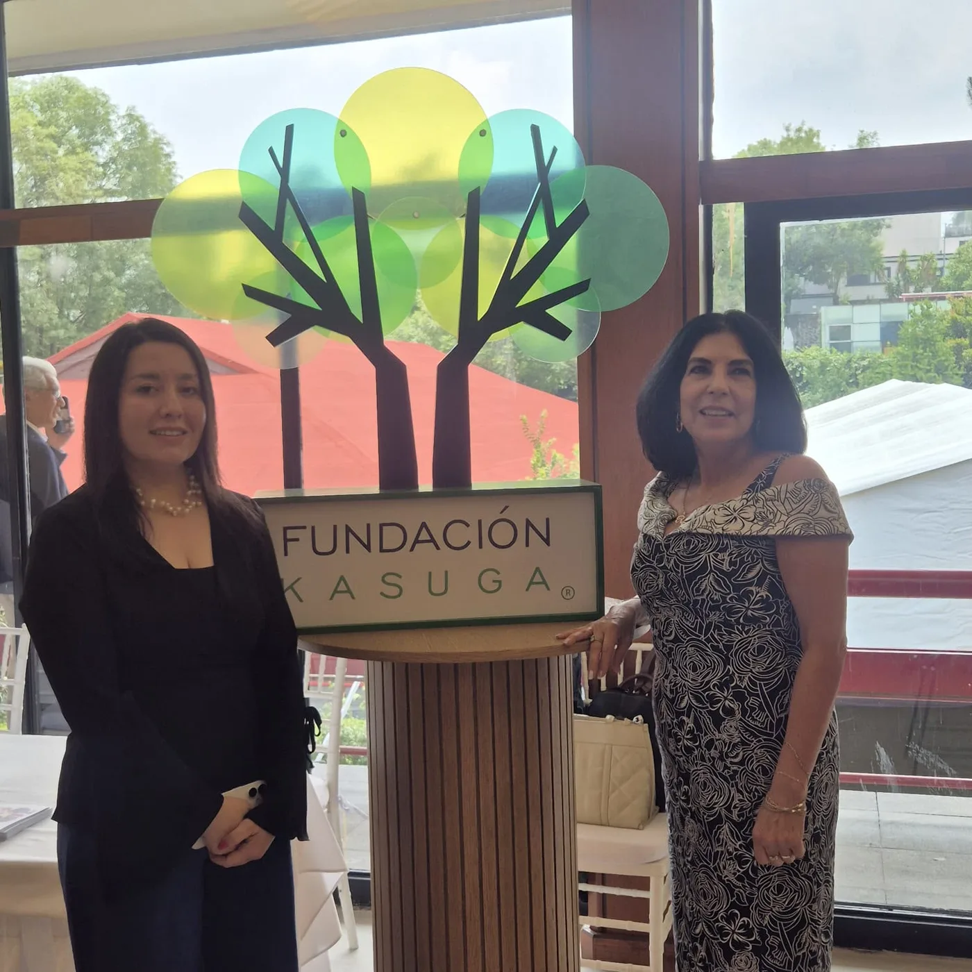 Directora de PROEDUCA junto al letrero de Fundación Kasuga