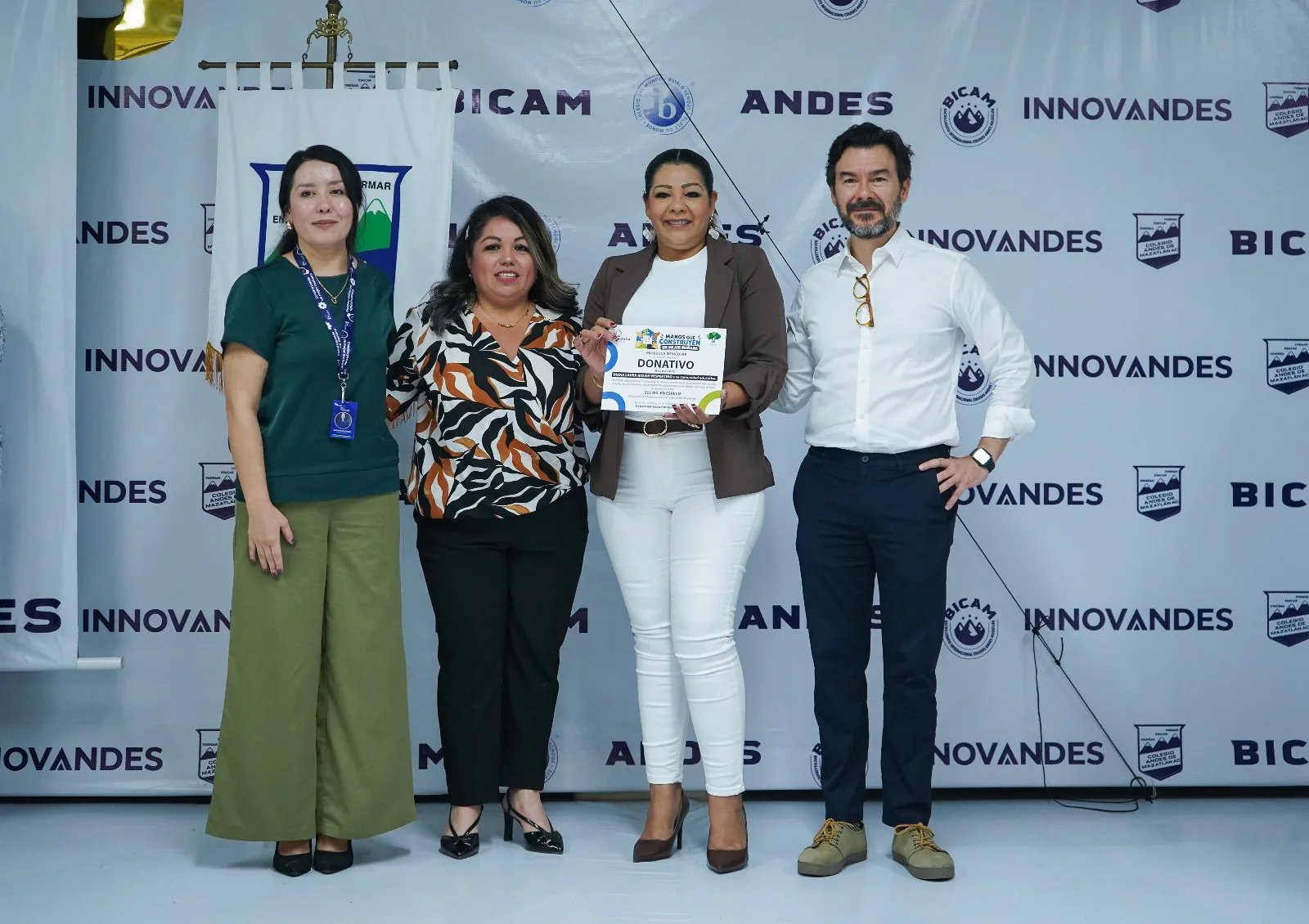 Representantes de instituciones aliadas sostienen sus reconocimientos de "Manos que Construyen un Mejor Mañana"