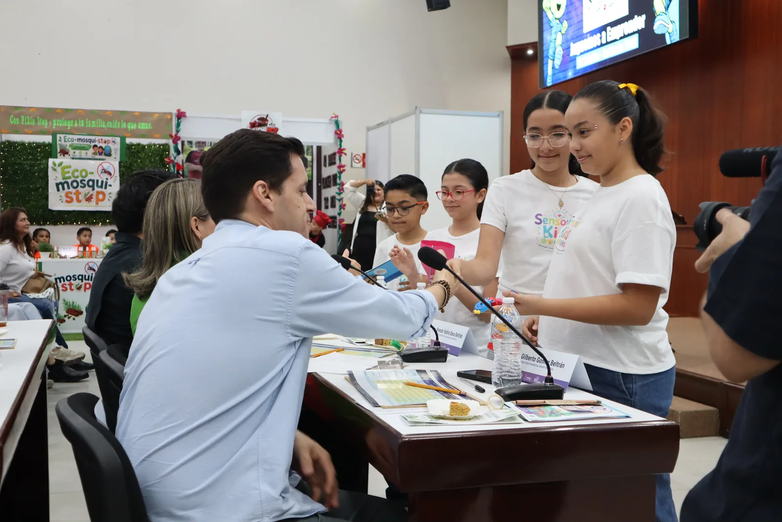 Un evaluador conversa con estudiantes sobre su proyecto Eco-mosqui-stop